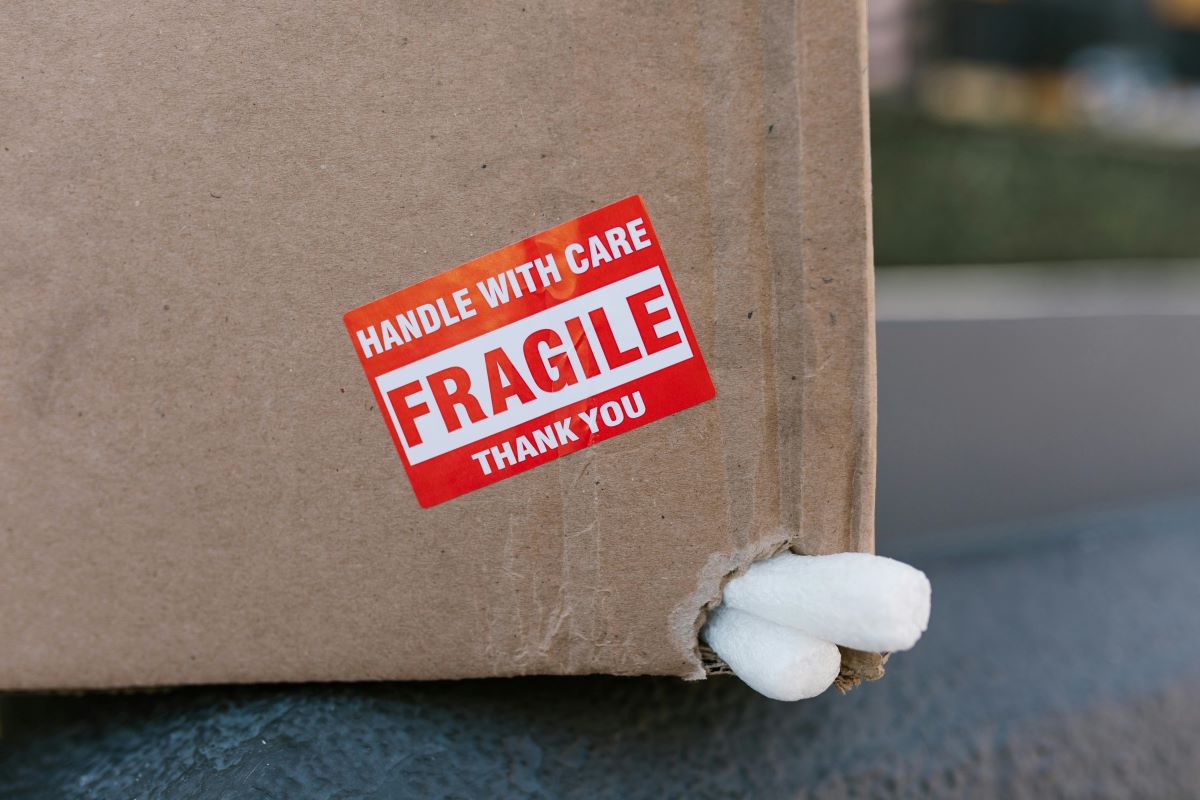 damaged cargo. Close up image of box with damaged corner and 'Fragile, handle with care sticker'